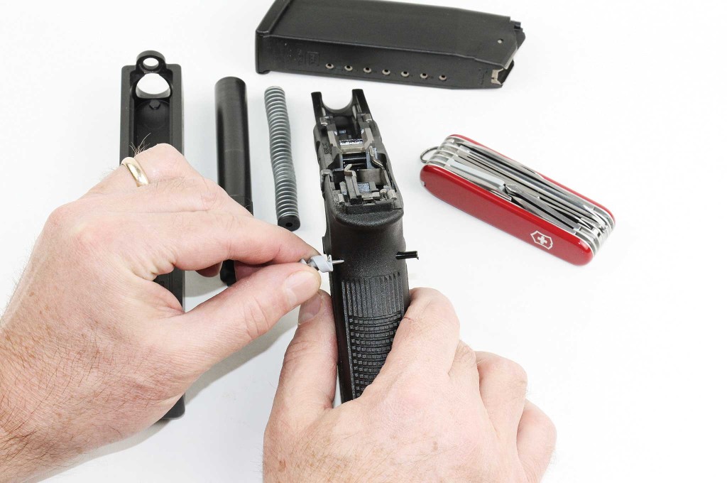 The author uses the tiny screwdriver from his Swiss Army knife as a pin punch to take down this Glock 20SF.