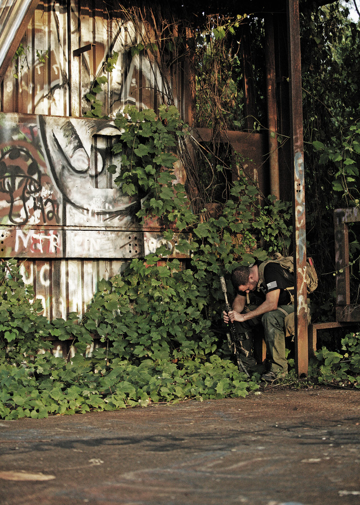 distressed-man-bowed-with-gun-and-survival-gear