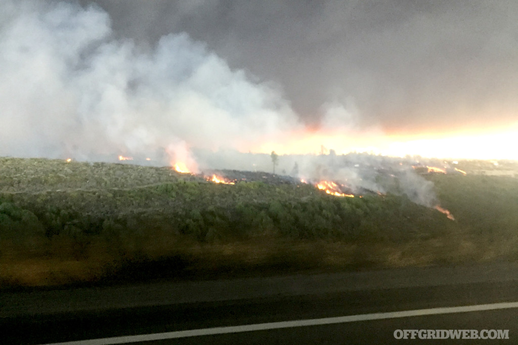 12:52 PM - Flames visible in the distance from the highway.
