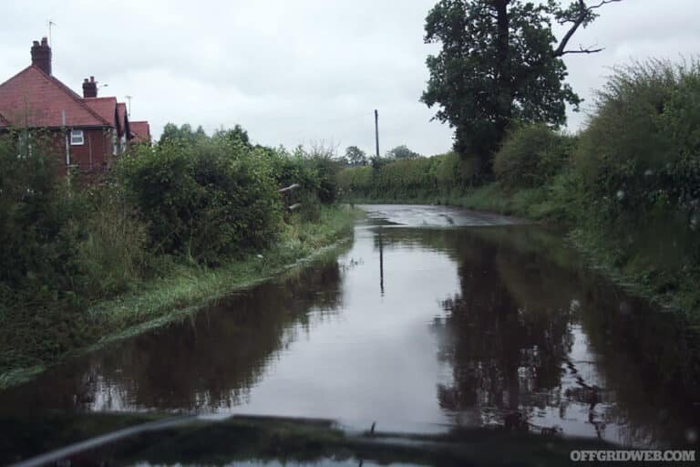 Photo from the inside of a vehicle stranded in flood waters on a country road.