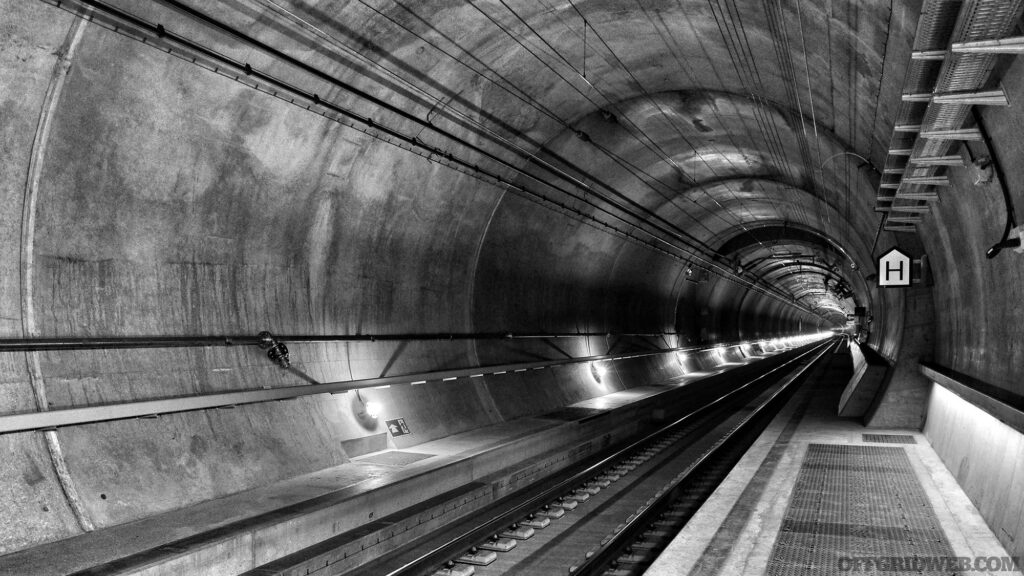 Black and white photo of an underground subway tunnel.