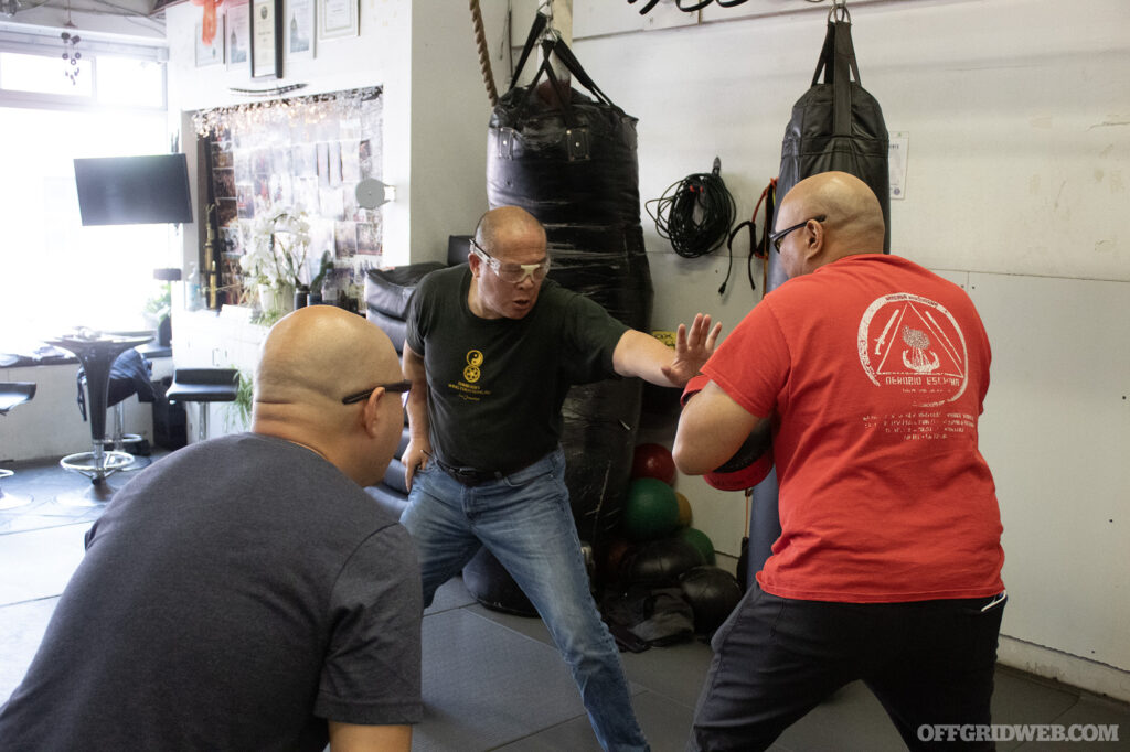 Photo of two students facing off during a knife defense sparring match.
