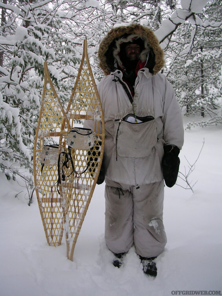 Michael Neiger geared up for freezing conditions, standing with large snowshoes.