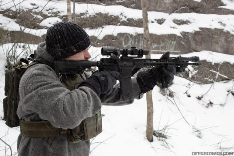 Photo of a man aiming a winter ready AR.