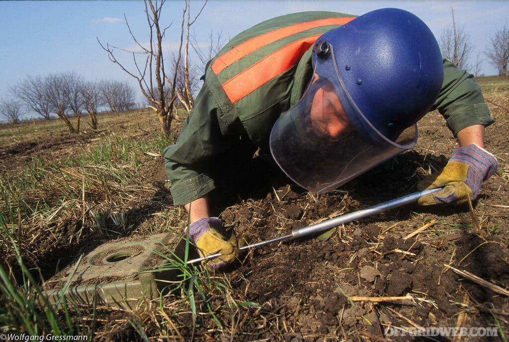 A man carefully attempts deactivating a mine during the Balkan War.