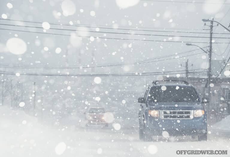 Motorists navigate a city street in white out conditions.