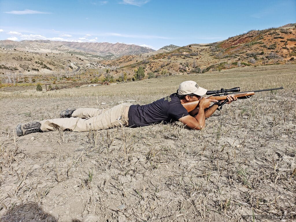 Photo of a man aiming with a rifle from the prone.