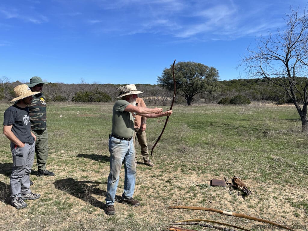 Photo of a student of the Primitive Wilderness Survival class determining his draw length.