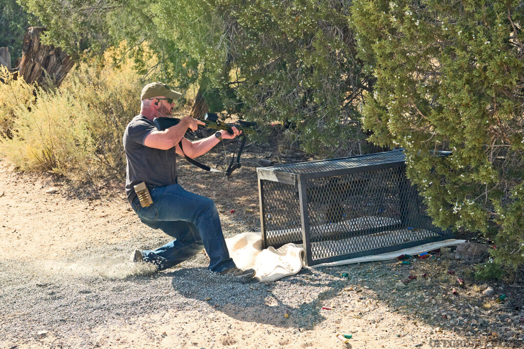 Studio photo of a man sliding into a shooting position.