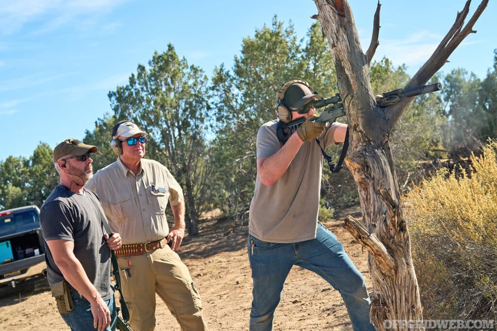 Photo of a man using a tree for support at a standing shooting position.