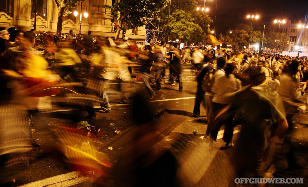 Motion blur photo of civil unrest on a street at night.
