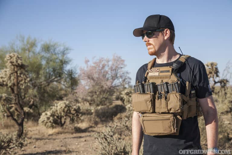 Photo of an adult male standing in the desert wearing a an armor plate carrier.