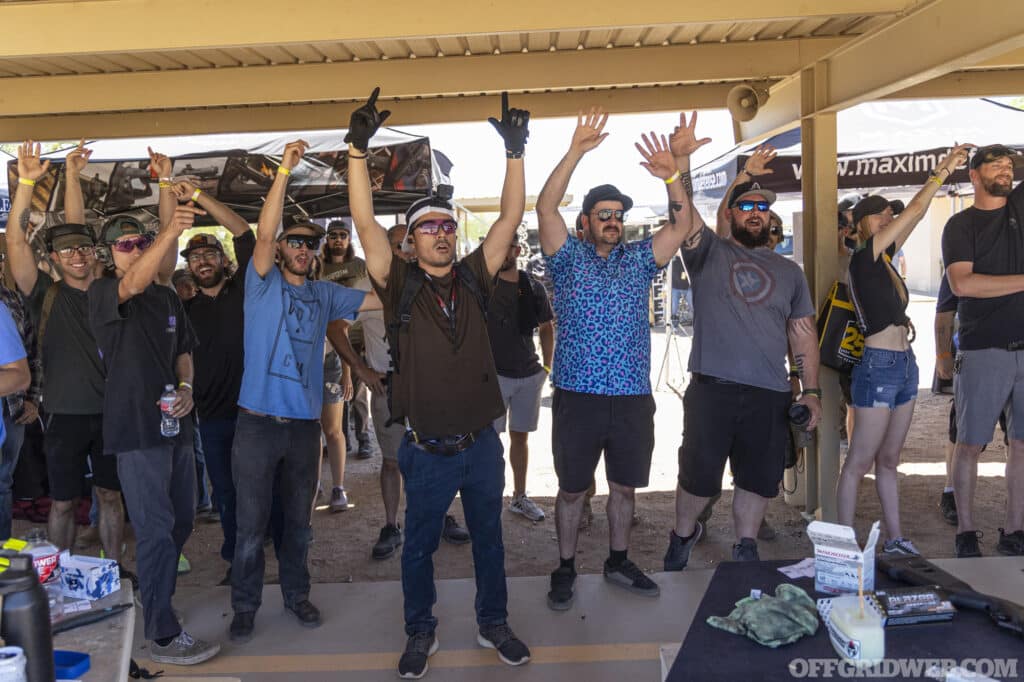 Group of CANCON participants raising their hands in the hopes of being selected to participate in the Pros vs Joes competition.