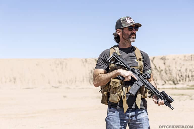 Bucky stands with rifle at the low ready wearing a Jungle Kit.
