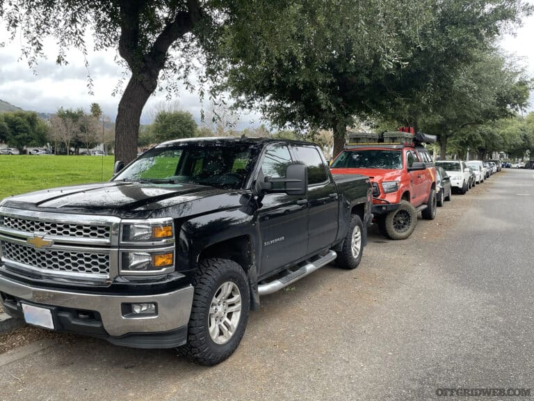 Several vehicles parked along the road in an urban area.