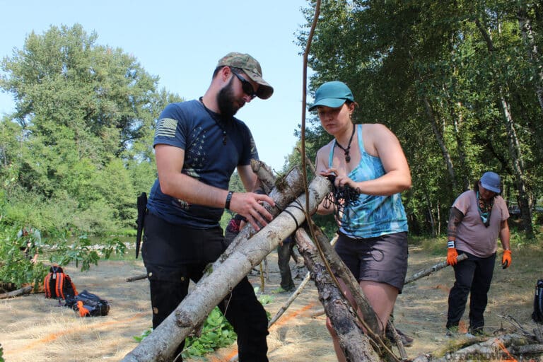 A team is constructing the frame of their shelter at the PNW Survival Games.