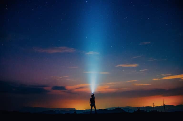 image of a person with a flashlight at dusk