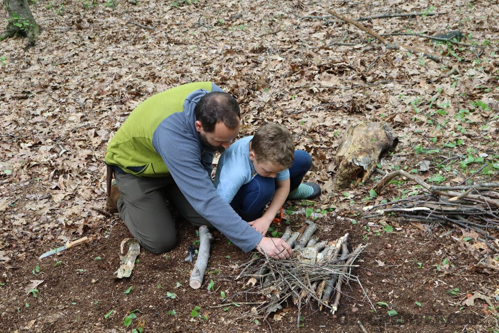 father and son practicing wilderness survival skills at raven wilderness school