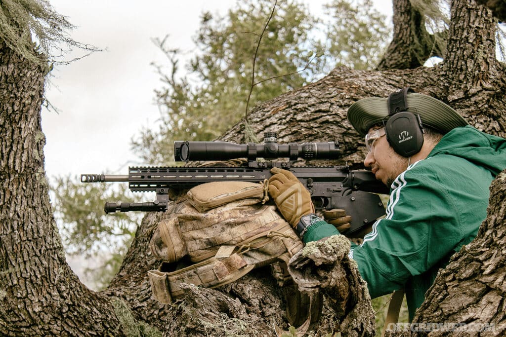 man looking into the scope of a rifle