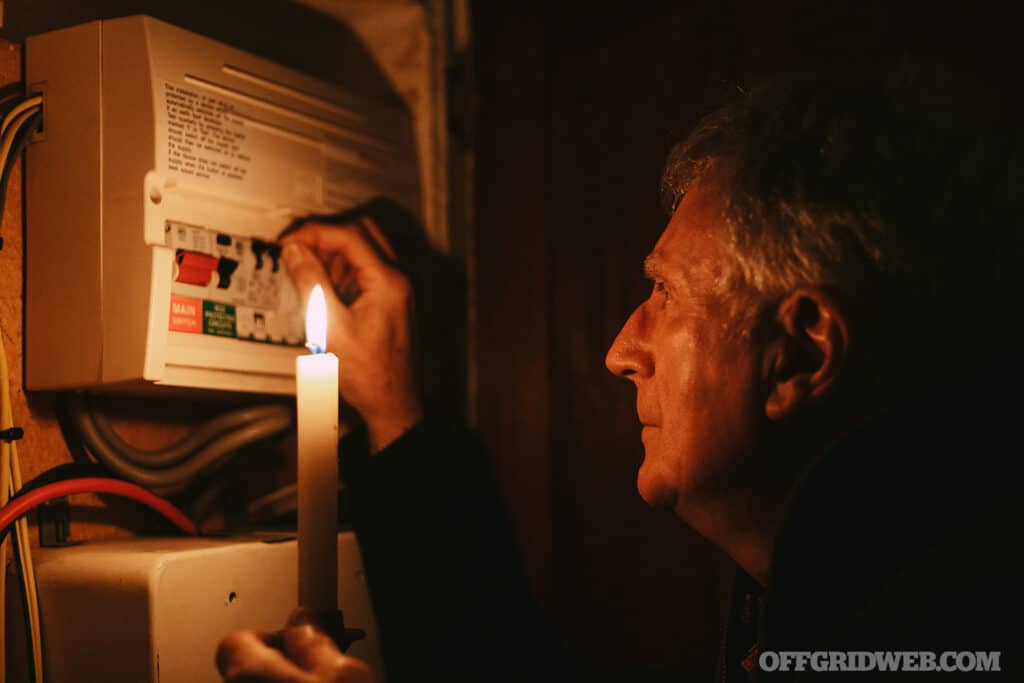 man holding a candle in the dark
