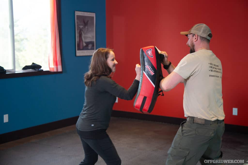 women working with a combative trainer at grey man academy