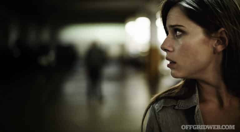 A terrified young woman in an underground parking garage being followed by a sinister man