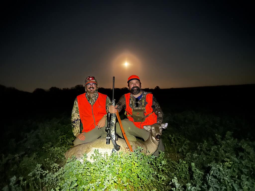 two hunters with a downed deer