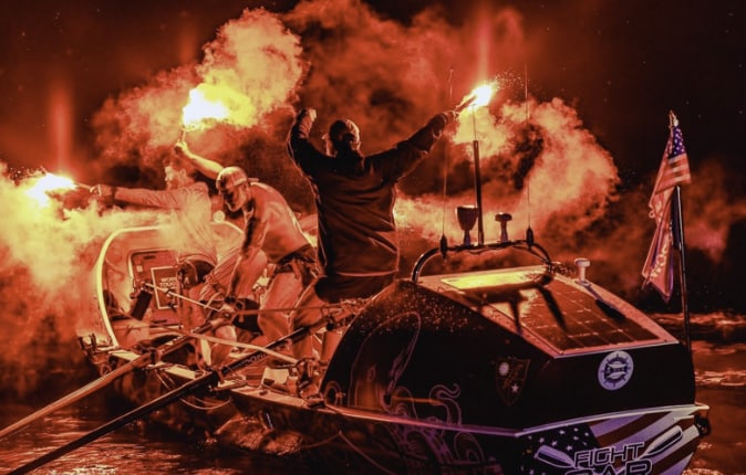 Ocean row training at night with signal flares.