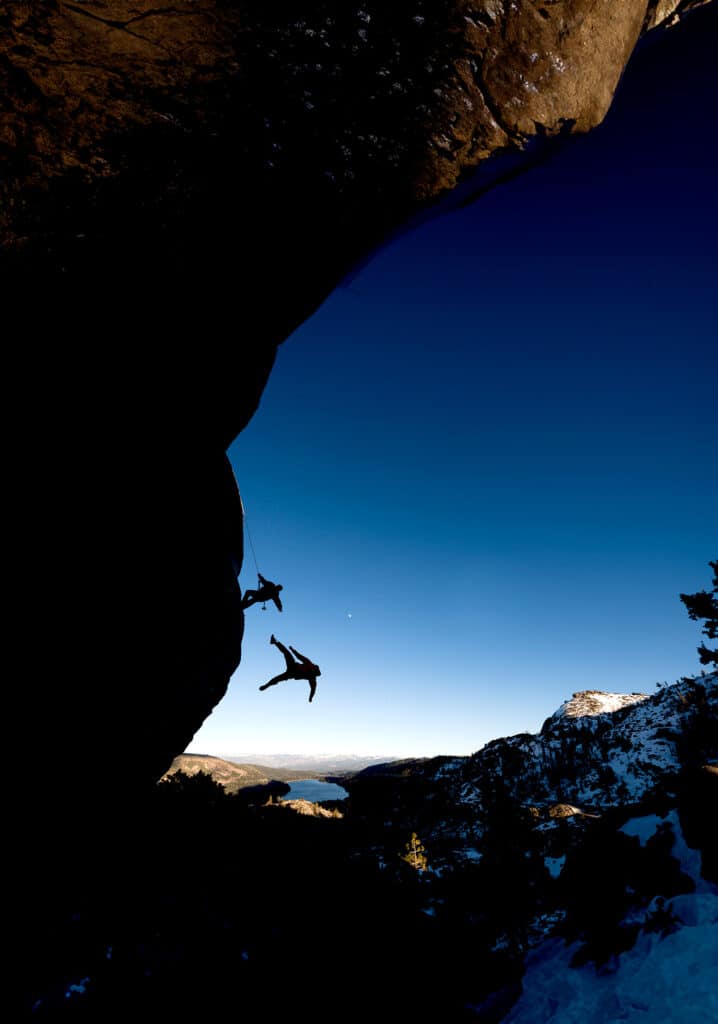 people scaling a mountain  cliff