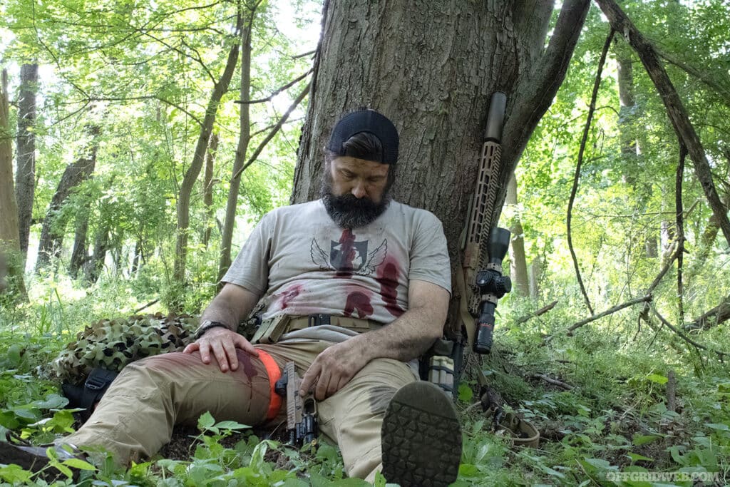 man who was shot up against tree