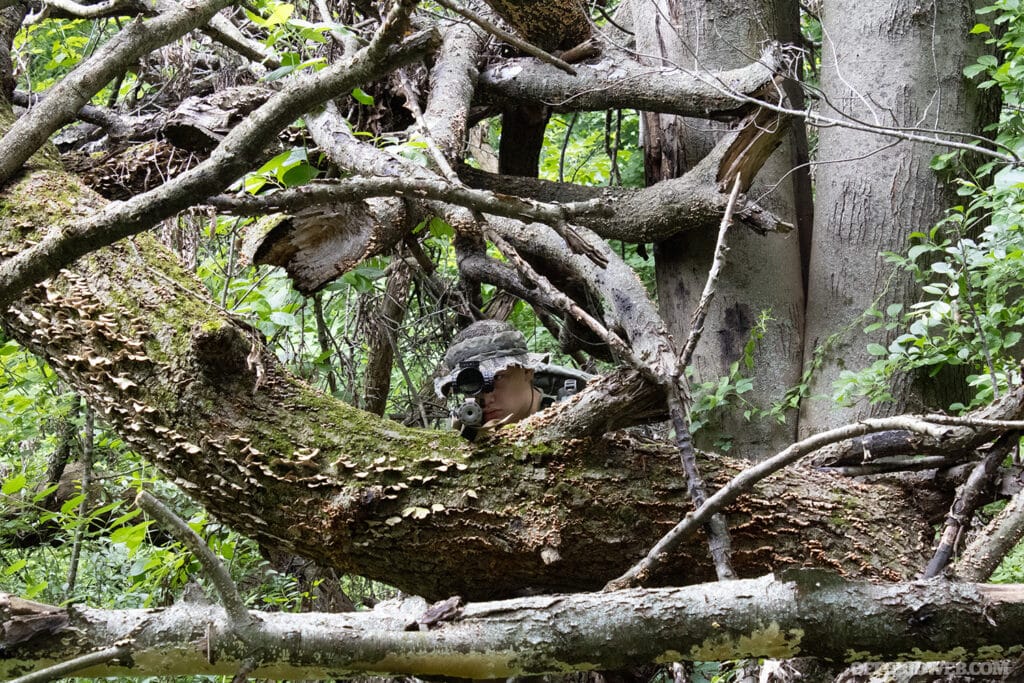 boy with rifle in trees